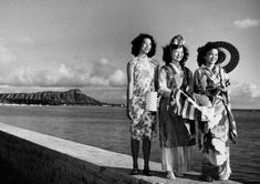 three women standing next to each other near the ocean