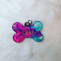 a dog bone shaped keychain with the word luna printed on it's side