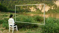 a woman sitting on a chair in front of a mirror that looks like it is floating