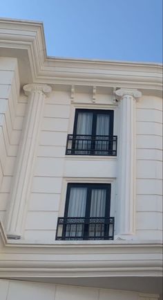 a white building with black balconies and windows