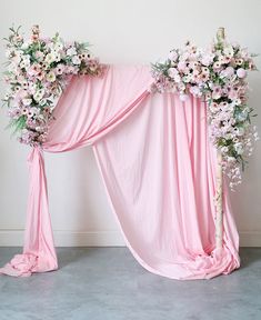 two pink drapes decorated with flowers and greenery