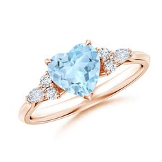 a blue topazte and diamond ring with three stones on the band, set in rose gold