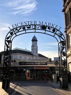 an archway leading to a market with a clock tower in the background