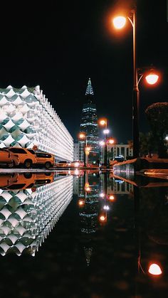 an image of a city at night with lights reflecting on the water and buildings in the background