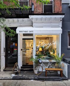 a storefront with a bicycle parked outside it on the sidewalk in front of an apartment building