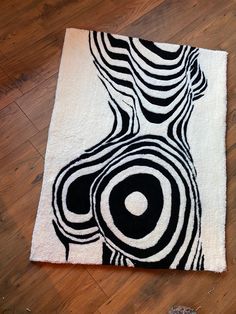 a black and white rug on the floor with an artistic design painted on it's side