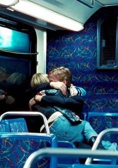 two people hugging each other on a bus