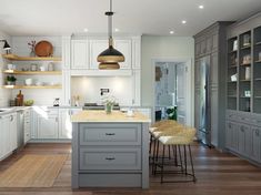 a large kitchen with white cabinets and gray counter tops, along with wooden flooring