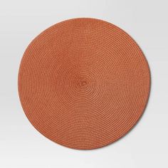 an orange round placemat on a white background