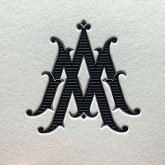 the letter m is made out of black and white paper with an ornate design on it