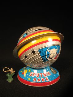 a small toy with a space ship on it's side and a keychain attached to it