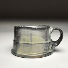 a white and gray cup sitting on top of a table