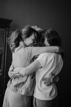 two girls hugging each other in black and white