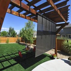 a backyard with grass and wooden pergols