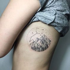 a woman's thigh with mountains and stars in the sky on her right side