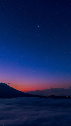 the night sky is filled with stars and clouds as seen from an airplane in the distance