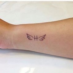 a person's arm with a small tattoo on the left side of their arm