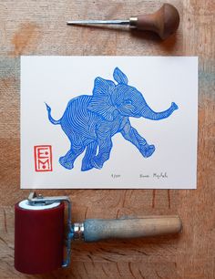 an elephant is drawn on a piece of paper next to a paint roller