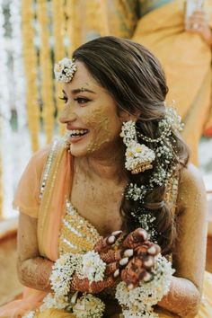 a woman with makeup on her face and flowers in her hair is smiling at the camera