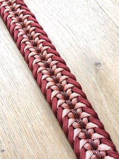 a close up of a red and white rope on a wooden surface