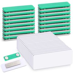 a stack of green and white boxes next to each other on top of a white surface