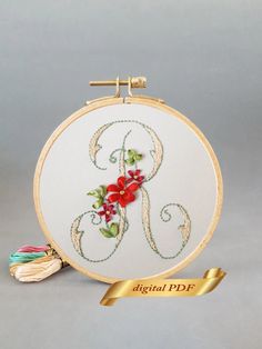 an embroidered monogram with red flowers on it