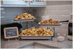 three trays filled with food sitting on top of a counter next to a sign