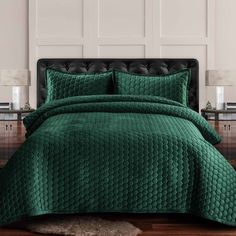 a bed with green bedspread and pillows