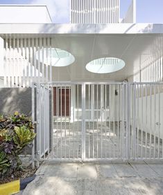 an open white gate in front of a building