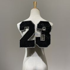 a white mannequin with black and silver numbers on it's back side