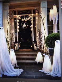 some fake ghost decorations are in front of a house