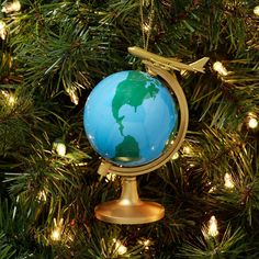 an ornament shaped like the earth on top of a christmas tree