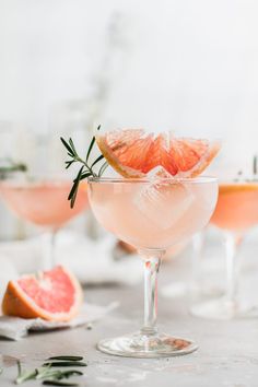 grapefruit martini with rosemary garnish in coupe glasses