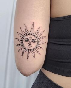 a woman's arm with a sun and moon tattoo on the left side of her body