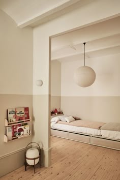 an empty bedroom with two beds and a hanging light