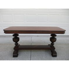 a wooden table sitting on top of a cement floor next to a white garage door