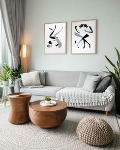 a living room with two paintings on the wall and furniture in front of it,