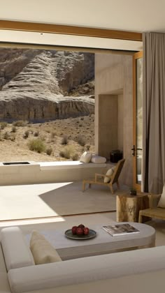 a living room filled with furniture and a large window overlooking the mountain side area in front of it