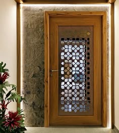 a wooden door sitting next to a potted plant on top of a stone floor