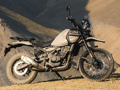 a motorcycle parked on top of a dirt hill