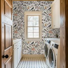 a washer and dryer in a small room with wallpaper on the walls