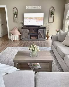 a living room filled with furniture and a flat screen tv on top of a wooden table