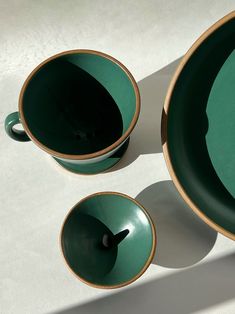 two green cups and saucers sitting next to each other