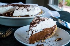 there is a slice of chocolate pie on the plate next to another piece of pie