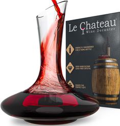 a wine decanter is being poured into a glass with red liquid in it