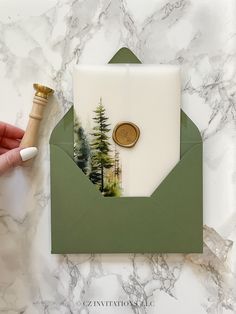 a green envelope with a button on it and a white card in the middle that says congratulations