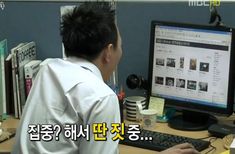 a man sitting in front of a computer monitor on top of a desk with a keyboard and mouse