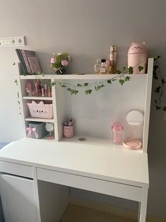 a white desk with shelves and plants on it