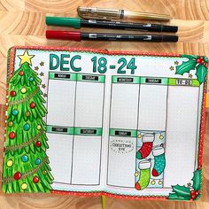 a christmas planner with markers and pencils next to it on top of a wooden table