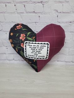 a heart shaped pillow with a quote on the side and flowers in black, red, white and pink